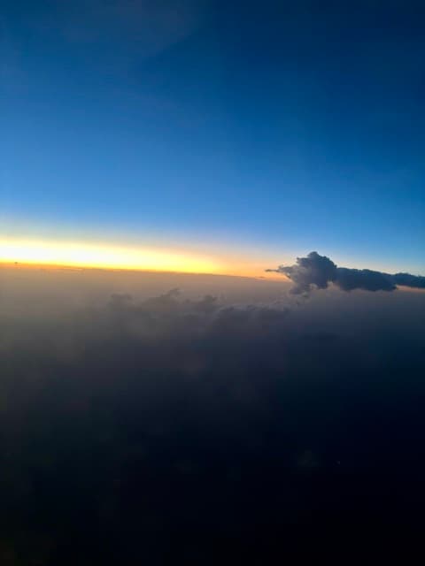 Sunrise over a sea of clouds from an aircraft window