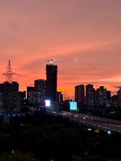 Crimson sunset with an aircraft light-trail over the city