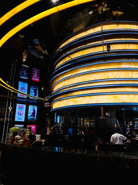 Golden circular atrium band glowing inside a dark hall